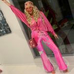 Person in pink sequined flared pants and matching top posing for a disco look.