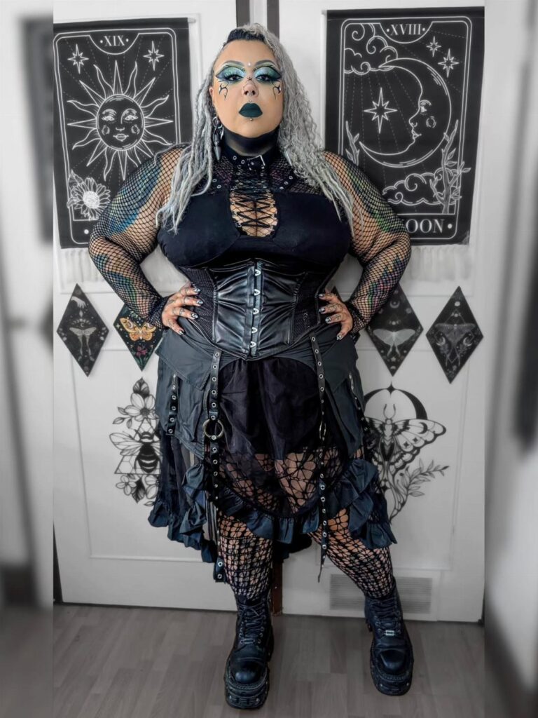 Plus-size person wearing a gothic black corset and ruffled skirt for a festival.